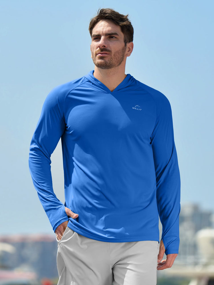 A man wearing a bright blue long-sleeve athletic hoodie standing outdoors 