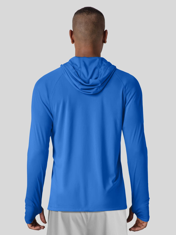 A man viewed from the back wearing a bright blue long-sleeve hooded athletic shirt 
