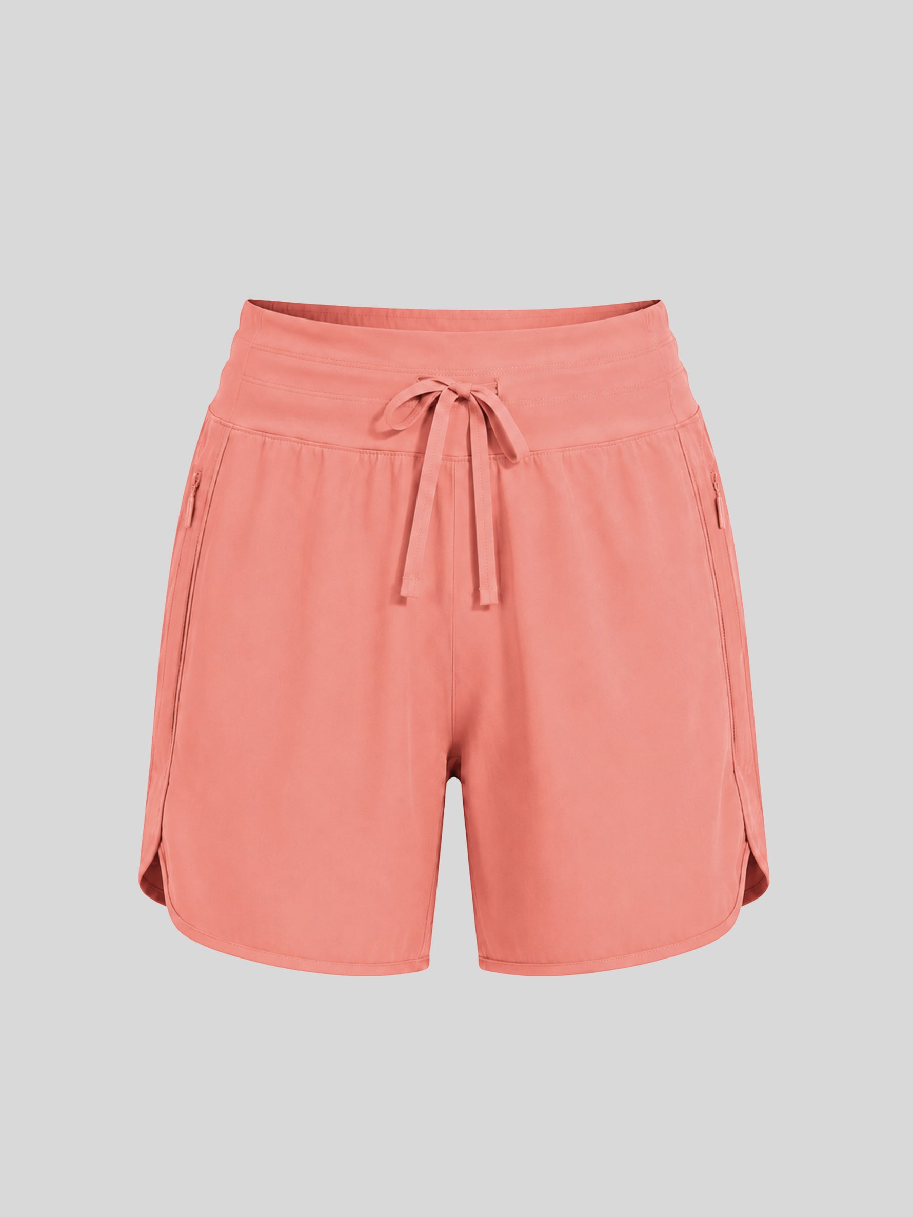 A pair of women's coral pink athletic shorts with an elastic waistband, drawstring, and side pockets 
