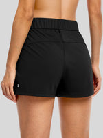 Rear view of a woman wearing black athletic shorts with an elastic waistband, 