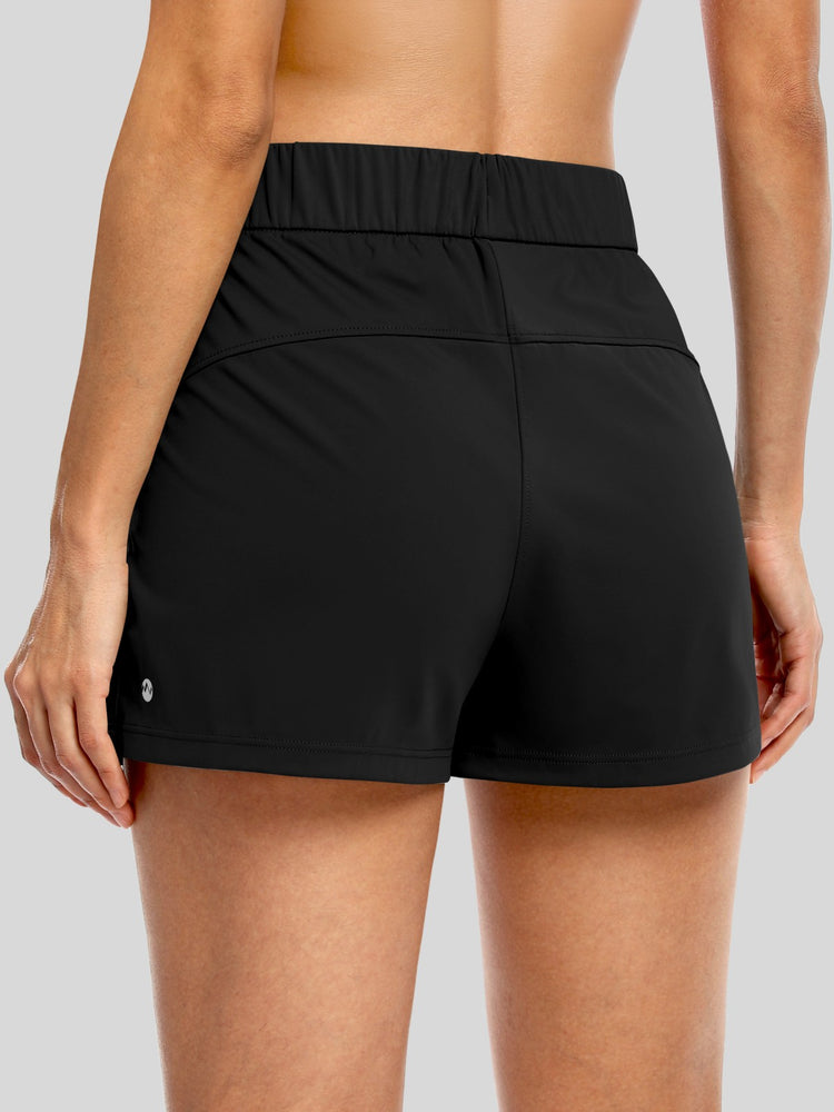 Rear view of a woman wearing black athletic shorts with an elastic waistband, 