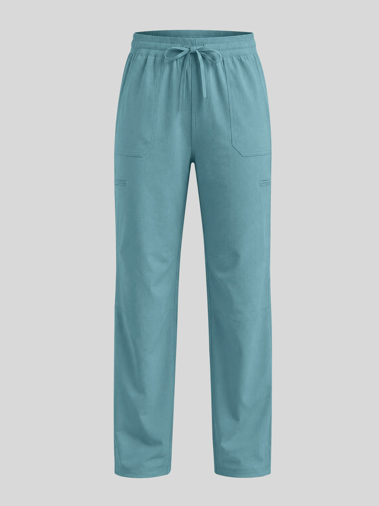 A pair of scrub pants in a dusty teal blue-green color, featuring an elastic waistband with a drawstring and two large cargo-style side pockets 