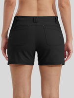 Rear view of a woman wearing black athletic shorts with a high waist, belt loops, and two large back patch pockets 