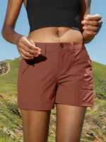 A close-up of a woman wearing rust-brown athletic shorts and a black sports bra 