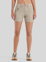 A model from the waist down wearing light beige athletic shorts with zippered pockets and hiking shoes 