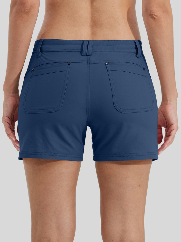 Rear view of a woman wearing blue athletic shorts with two large back patch pockets 