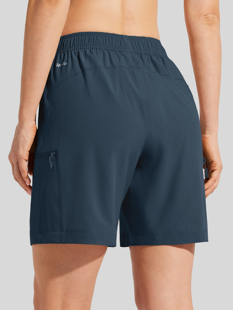 Rear view of a person wearing dark slate blue athletic shorts with an elastic waistband and side zip pocket 