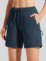 A close-up of a woman wearing dark navy blue athletic shorts with an elastic drawstring waist, side pockets, and a zippered pocket 