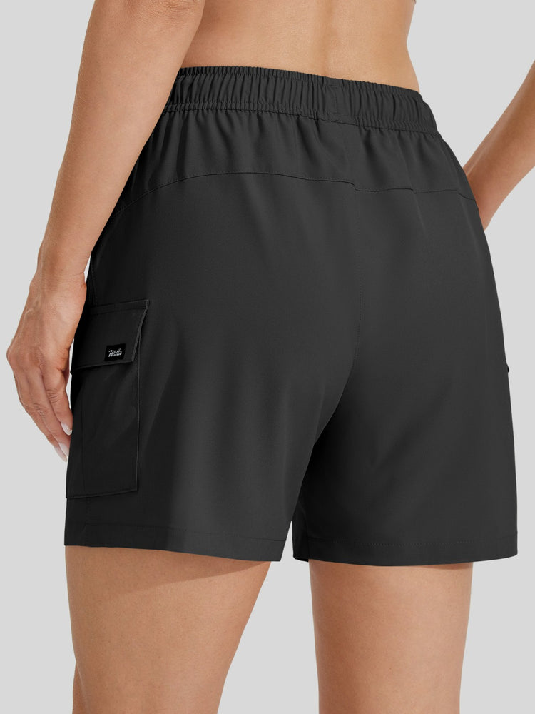 Rear view of a woman wearing black cargo-style athletic shorts with an elastic waistband and side cargo pocket 