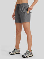 A woman wearing gray athletic shorts with a drawstring waist and a side cargo pocket 