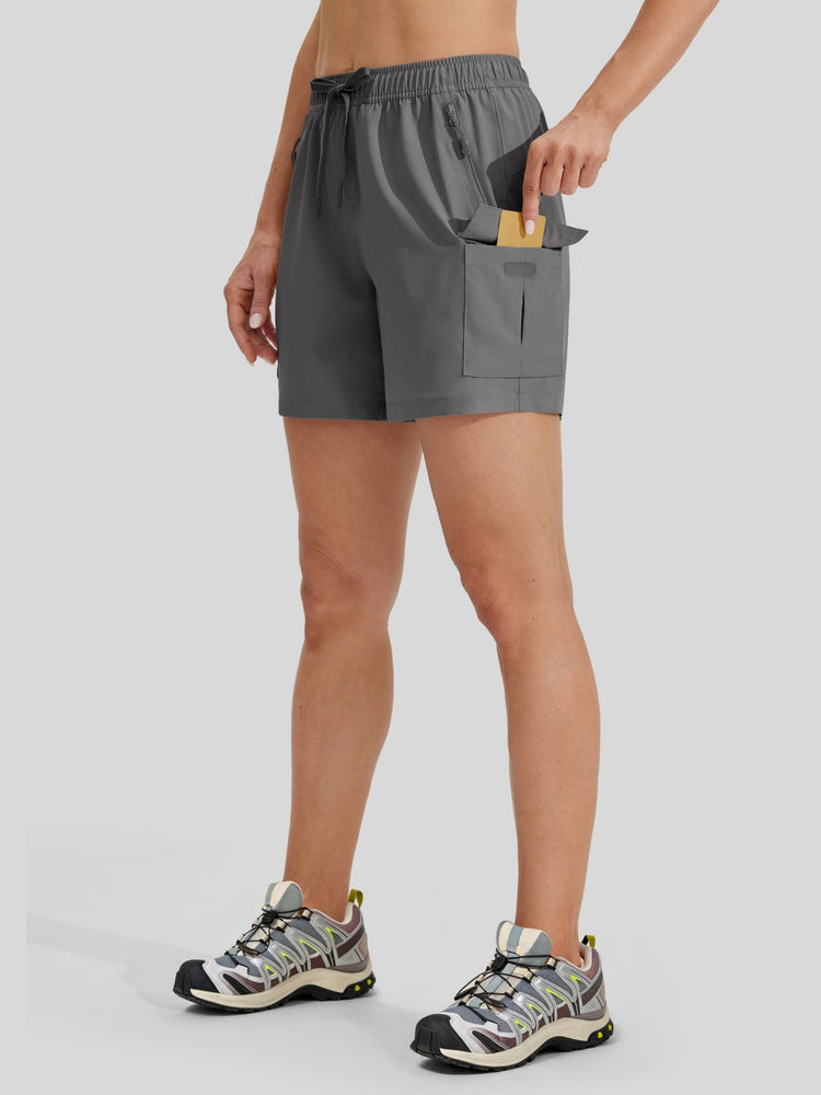 A woman wearing gray athletic shorts with a drawstring waist and a side cargo pocket 