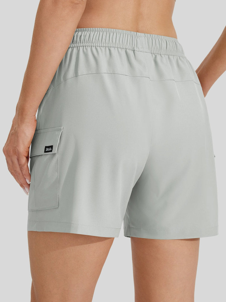A close-up back view of a female model wearing light gray athletic shorts with an elastic waistband and a side cargo pocket 