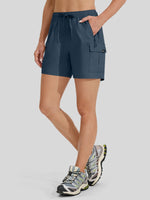 A model wearing slate blue cargo shorts with a drawstring waist and side cargo pocket 