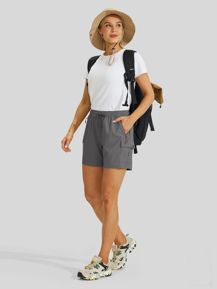 Woman wearing gray shorts, white shirt, and hat 