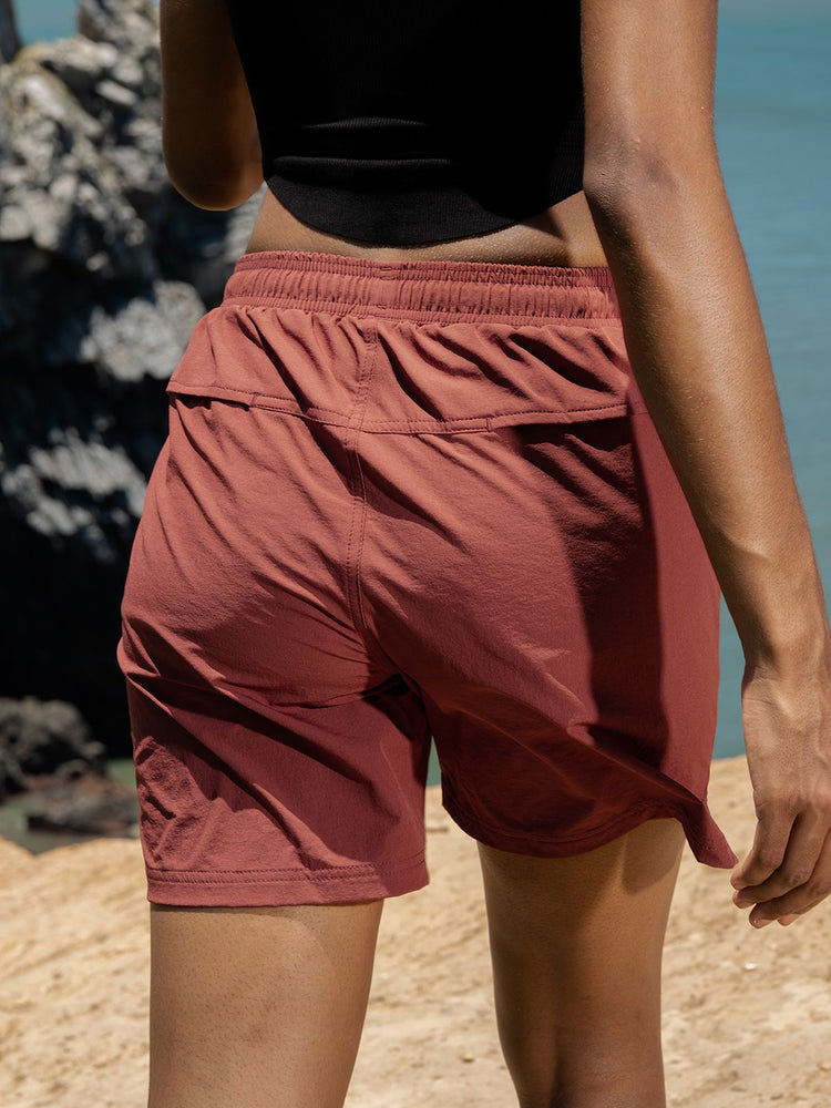 A close-up back view of a women wearing dusty rose athletic shorts 