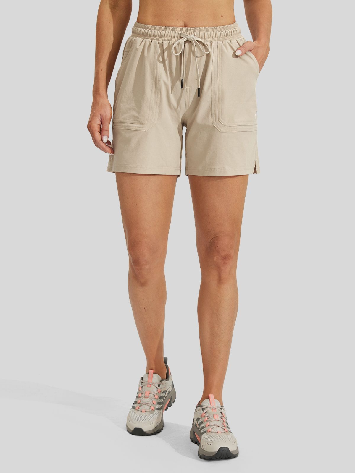 women wearing beige athletic shorts with a drawstring waist and side pockets 