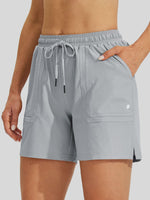 A close-up of a women wearing light gray athletic shorts with an elastic drawstring waist, side pockets 
