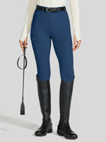Person wearing blue equestrian pants and black riding boots 