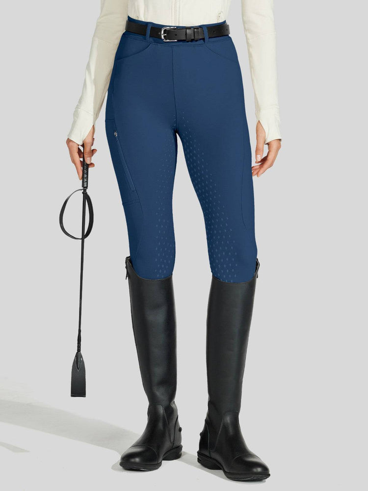 Person wearing blue equestrian pants and black riding boots 