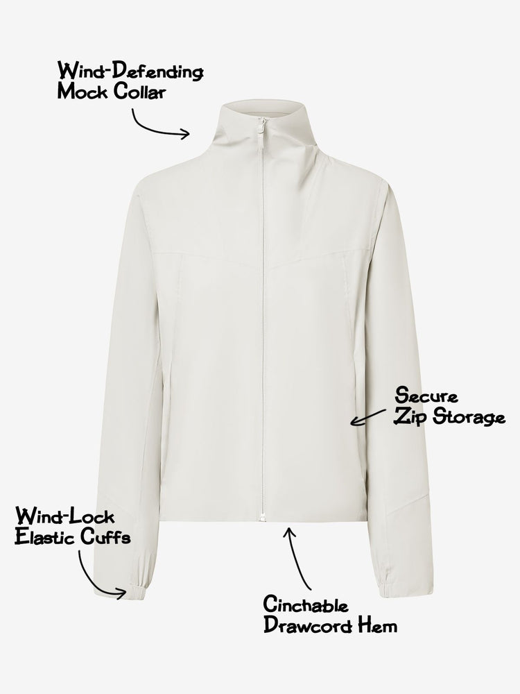 An off-white zip-up jacket with a mock collar, highlighting features like a wind-defending mock collar, secure zip storage, wind-lock elastic cuffs, and cinchable drawcord hem. 