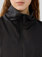 Close-up of a woman wearing a black high-collar zip-front jacket 