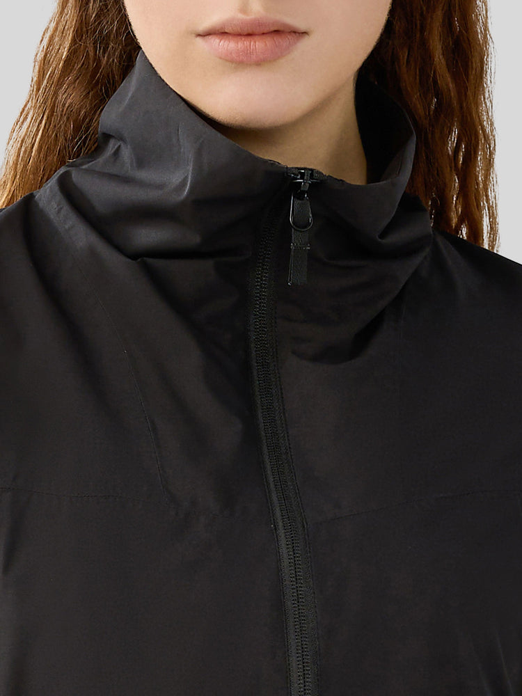 Close-up of a woman wearing a black high-collar zip-front jacket 