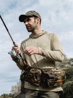 A man holding a fishing rod wearing a sun protection hoodie 