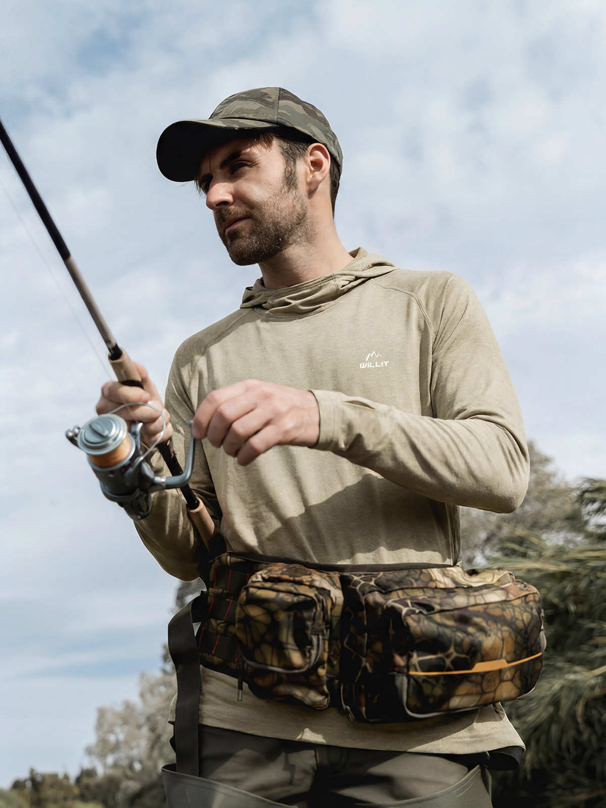 A man holding a fishing rod wearing a sun protection hoodie 